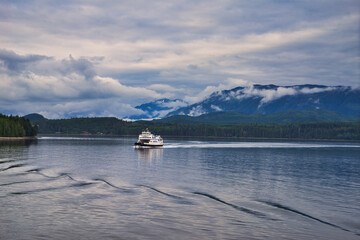 The ferry boat sails on the lake. Beautiful scenery on both sides of the fjord.