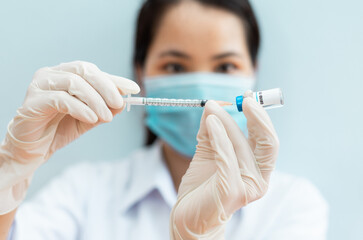 image of a female nurse holding a covid 19 vaccine