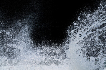 splashing of sea wave crashing on shore spraying white water foam - Powered by Adobe