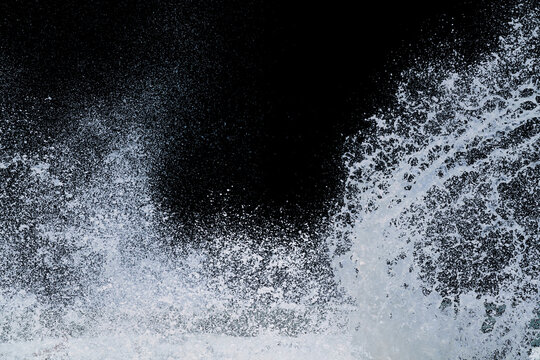 splashing of sea wave crashing on shore spraying white water foam