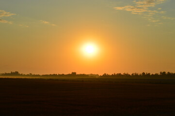Orange dawn early in the morning over the field