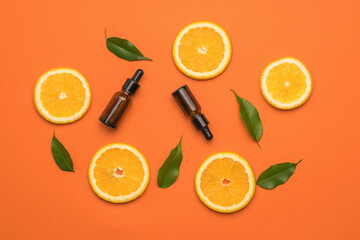 Orange background with orange slices, green leaves and bottles with pipettes.