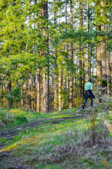 Man is engaged in hiking exercising on a rocky forest cascade path