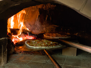 pizza in charcoal oven with fire