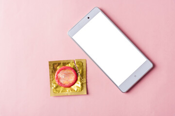 World sexual health or Aids day, Top view flat lay condom in wrapper pack and smart mobile phone...