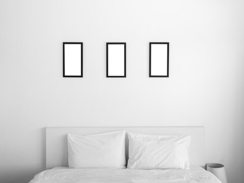 Group Of Three Mockup Photo Frames. White Square Picture Black Frame Mockup, Vertical Style Hanging On The White Wall Background Over The Bed In The Bedroom.