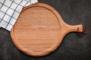 Empty wooden pizza platter set up on dark concrete. Pizza tray on dark concrete background flat lay and copy space.