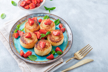  Cottage cheese pancakes with strawberries and mint on a blue plate. Photo with free space for text