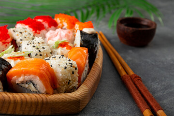 Japanese rolls on a plate on gray concrete background close up
