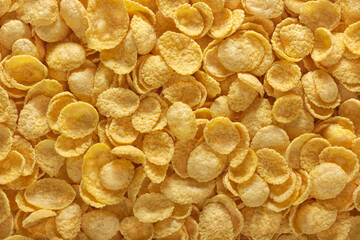 Corn flakes background. Cornflakes scattered on a table. Close up top view.