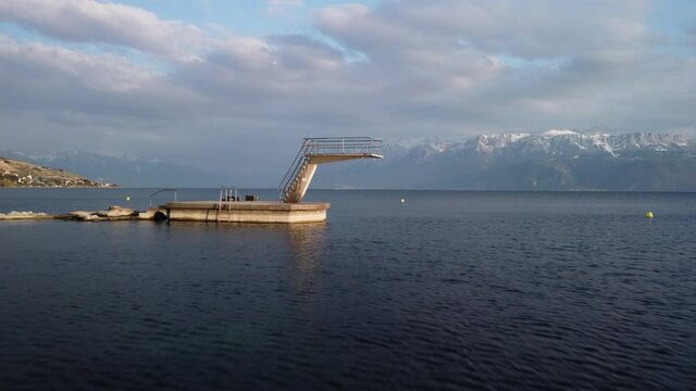 Fast aerial fly over of a large diving board into Lake Geneva near Lutry, Switzerland.