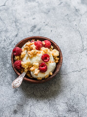 Homemade frozen yogurt ice cream with raspberries and sugar crumb cookies on a grey stone background, top view