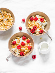 Tasty breakfast, brunch - cottage cheese with greek yogurt, raspberries and sugar cookies crumbs on a light background, top view