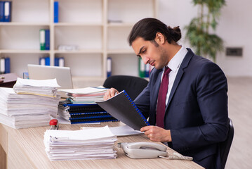Fototapeta premium Young male employee unhappy with excessive work