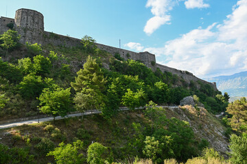 Fototapeta na wymiar The Kalaja e Gjirokastrës castle of Gjirokastra with green trees in summer and blue sky in Albania