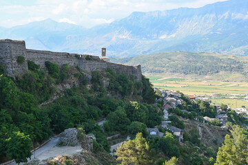 Fototapeta na wymiar Panorama over Gjirokastra in Albania with the bell tower, clock tower of Kalaja e Gjirokastres castle with mountains in the background