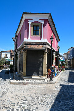 Typische Stra&szlig;enszene mit traditionellem Haus in rosa Farbe in Basar-Viertel von Korca in Albanien