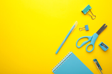 Blue school supplies on yellow background. Back to school concept.