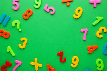 Many colorful numbers on green background with copy space.