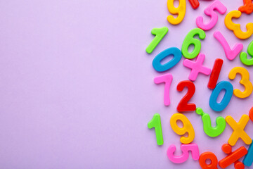 Magnetic multi-coloured figures on purple background with copy space. Back to school.