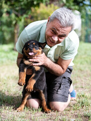 man and puppy rottweiler in studio
