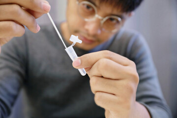 Man uses cotton swab to test for Covid-19 Insert a reagent bottle to look for what is believed to be a virus.