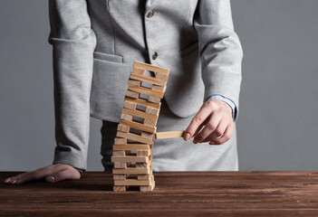 Businesswoman removing wooden block from tower