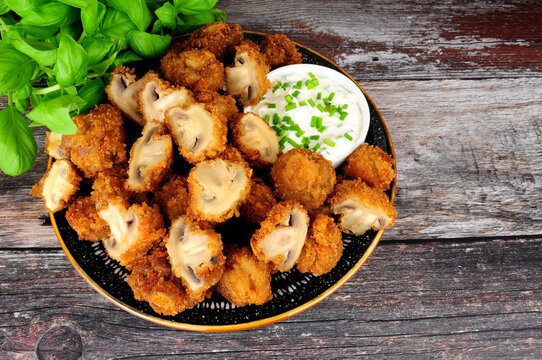 Whole breaded button mushrooms with soured cream and chive dip