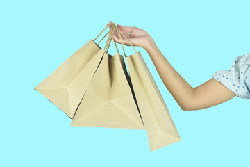 Fototapeta na wymiar Woman hand holding shopping bags on white background.
