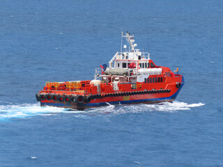 Fototapeta premium Supply boat transfer the cargo for supporting oil and gas industry and moving cargo from the boat to the platform. Boat is waiting transfer cargo and crews to platform.