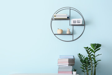 Shelf with books, clock and decor hanging on color wall