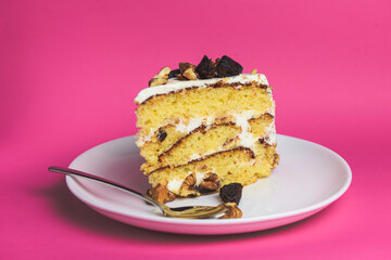 Pistachio cake, sponge cake with nuts decoration on a white plate. One piece of freshly baked cake.