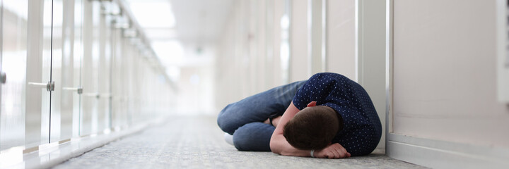 Young man sleeps under door of hotel complex