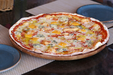 pizza four cheeses on a thin dough is on the table