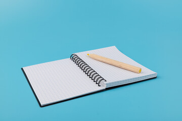 Blank paper and pencil on a blue background