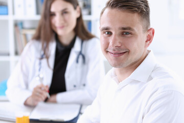 Satisfied happy handsome smiling male patient with doctor