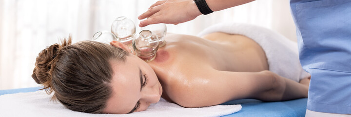 Woman Getting Cupping Treatment At a Spa. Cupping Therapy. Treatment used in Traditional Chinese...
