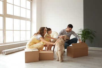 Happy family with dog and moving boxes in their new house