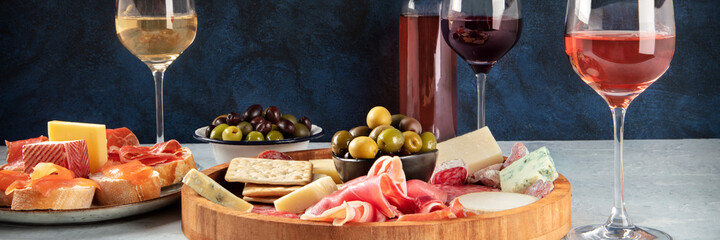 Italian antipasti or Spanish tapas panorama with wine, cold meat and cheese. Rose, white and red...