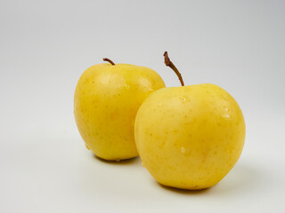 Fresh yellow apple with water drops, isolated on a white background