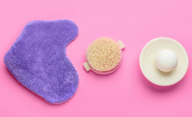 Bath bomb, massage glove and brush on color background