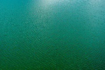 Blue azure water filling gravel pit holes. Texture.