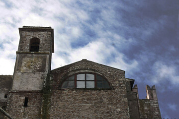 Detail of the Baronial Castle, XI-XII century, of Calcata, Italy. Tower and crenellated walls with cloudy and gray sky. Calcata, Italy.