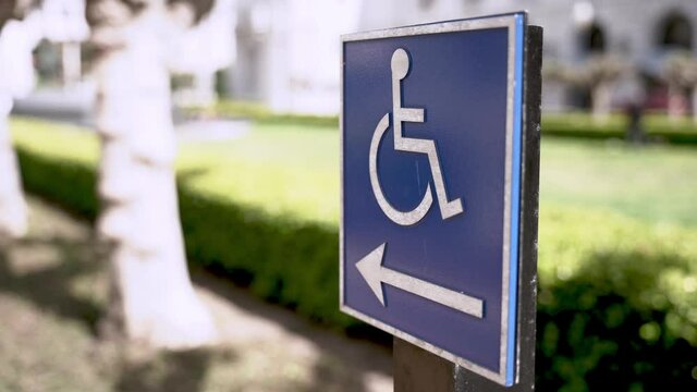 Sign with a handicap image and a left arrow