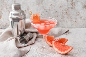 Glass of Hemingway daiquiri cocktail, grapefruit and shaker on grunge background