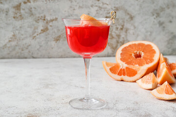 Glass of Hemingway daiquiri cocktail and grapefruit on grunge background