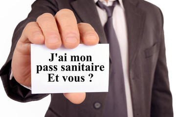 Homme tenant une carte sur laquelle est écrit en français j'ai mon pass sanitaire et vous ?