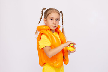 Young girl with yellow life-jacket and rubber duck on a white background.