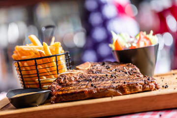 Beef steak meal with salad and french fries in american restaurant