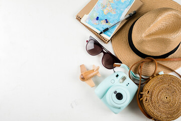 Fototapeta na wymiar Travel flat lay. Rattan bag, straw hat, sunglasses, camera and airplane. Top view, copy space